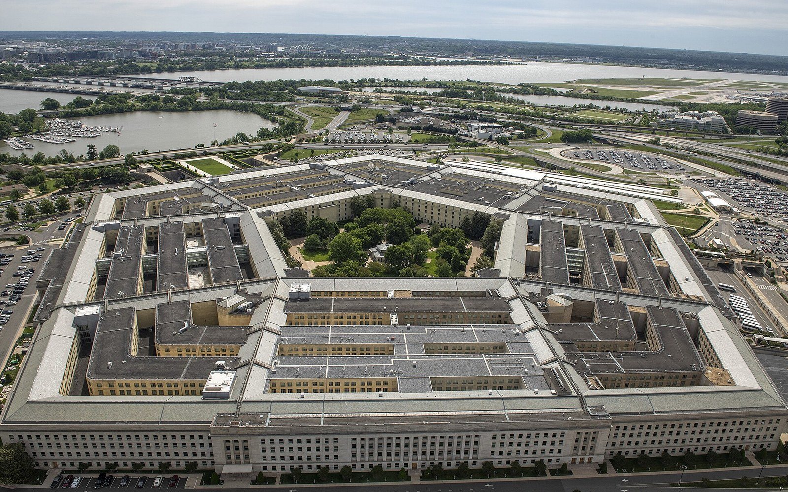An aerial view of the five sided headquarters building of the United States Department of Defense, with its courtyard, car parks and the river beyond