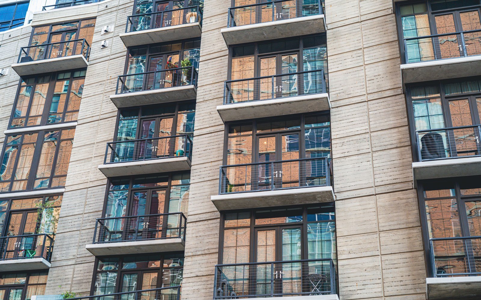 A modern residential block with glazed balconies on several storeys
