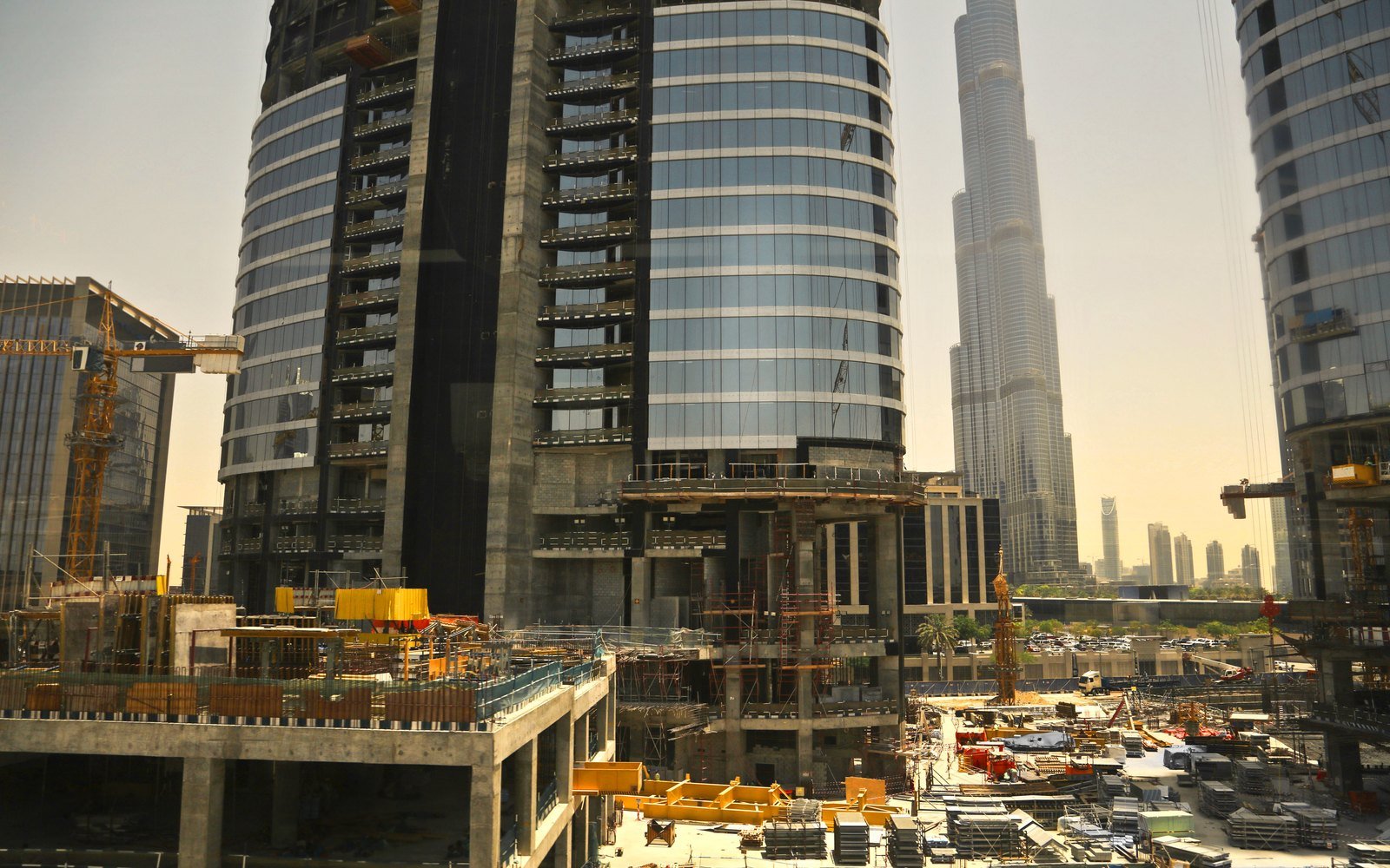 High rise buildings under construction in Dubai with tower cranes and formwork on the working deck