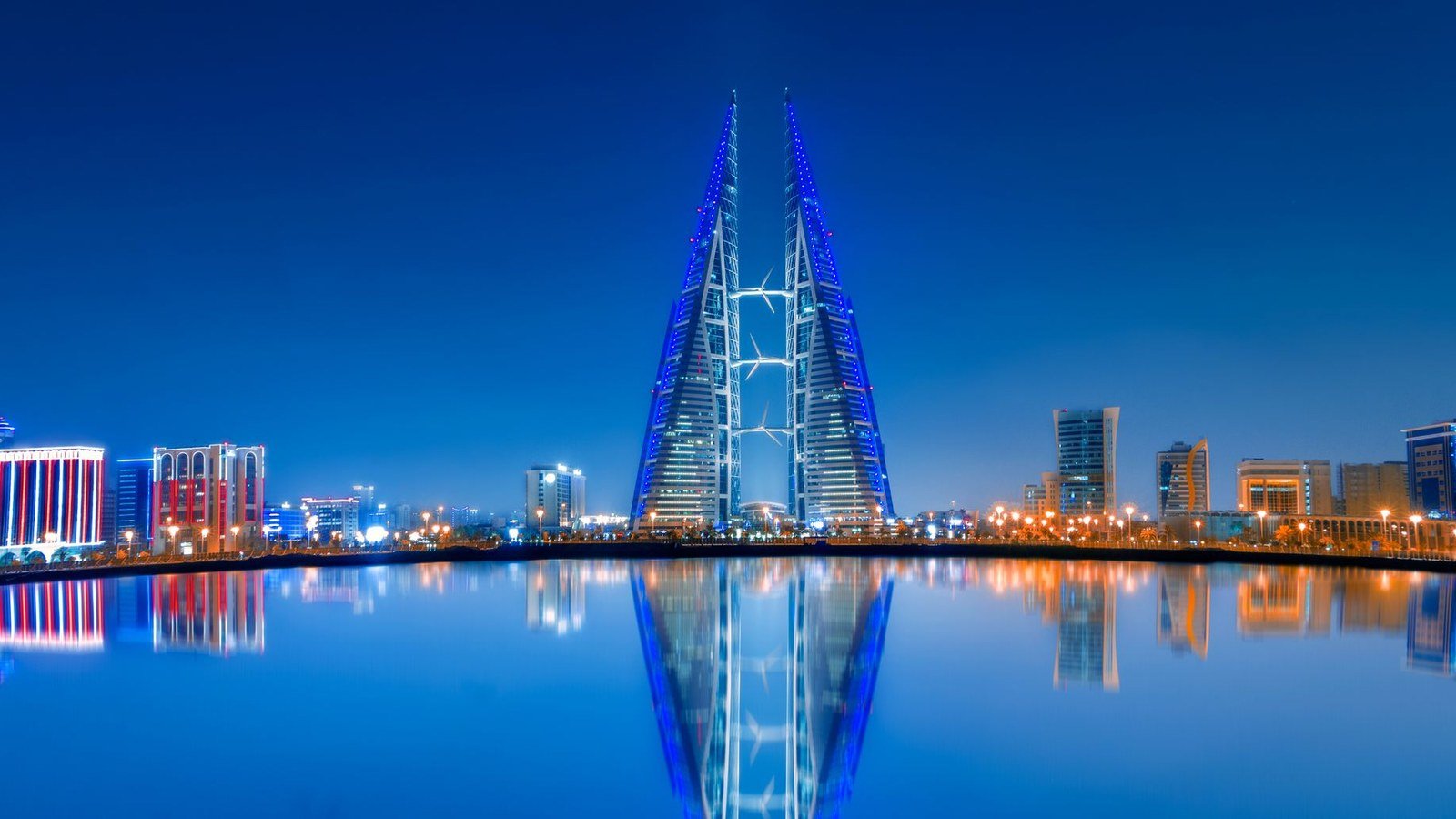 The Bahrain World Trade Center towers lit at dusk above the water