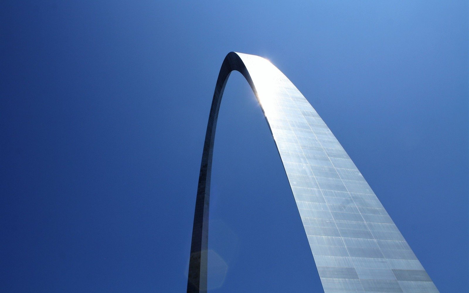 The stainless steel curve of the Gateway Arch in St Louis rising against a clear blue sky