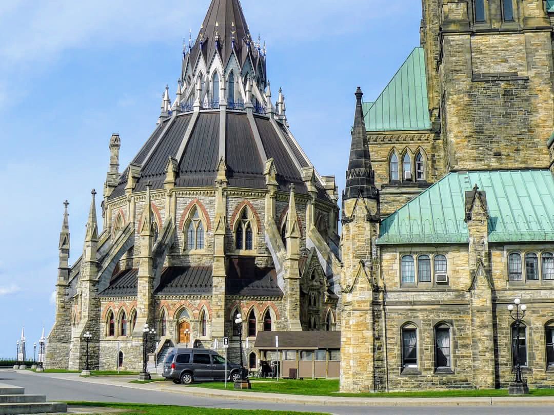 The stone and copper roofed Library of Parliament on Parliament Hill in Ottawa, seen from the lawn on a clear day