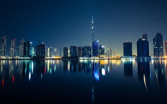 The Dubai skyline at night reflected in water