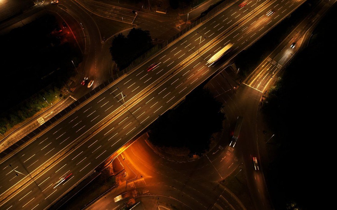 An aerial view of a lit motorway junction at night in Luton