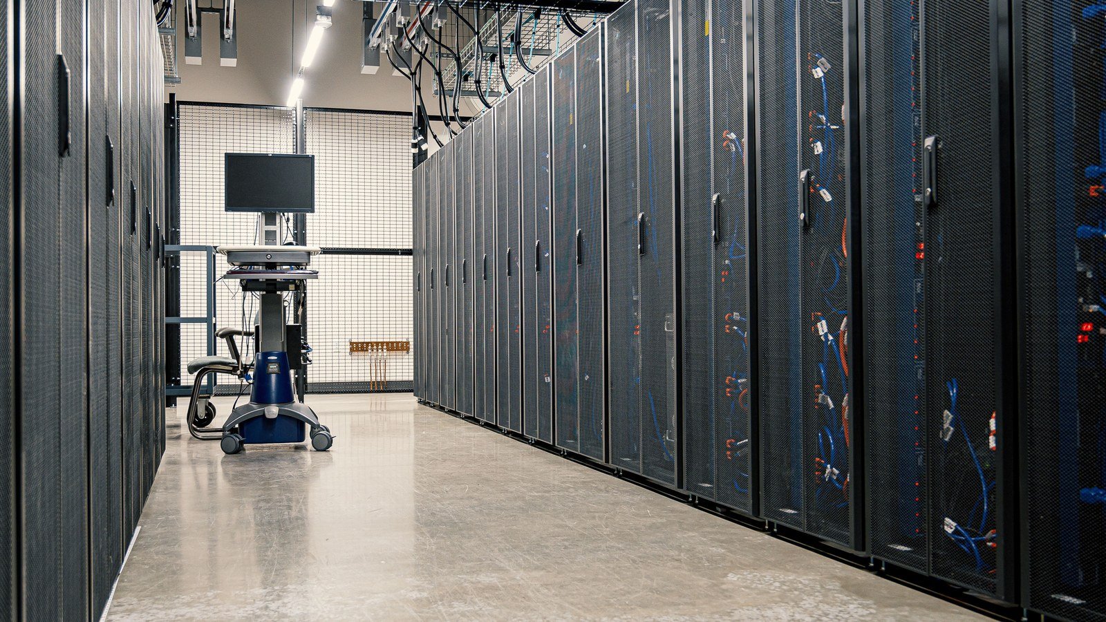 Rows of server cabinets and patch cabling in a data centre aisle