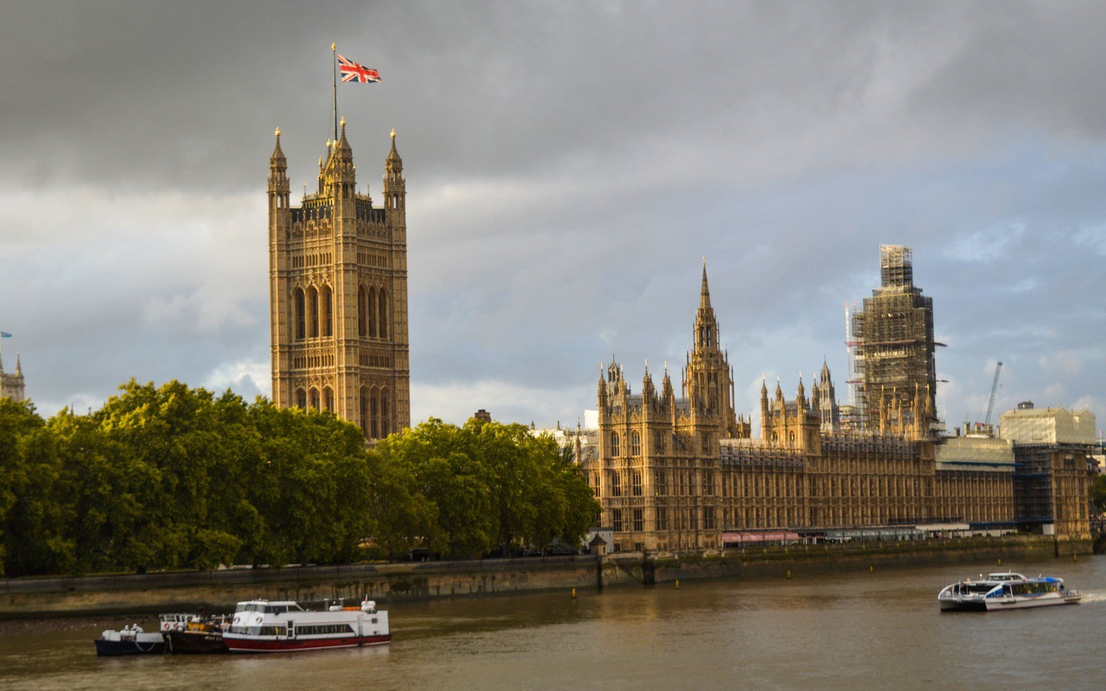 The Palace of Westminster seen across the Thames in late afternoon light, with scaffolding still on the clock tower
