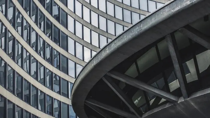 The curved glazed flank of an office building meeting its ring beam