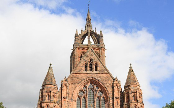 A gothic sandstone church tower and gable in Paisley against a bright sky