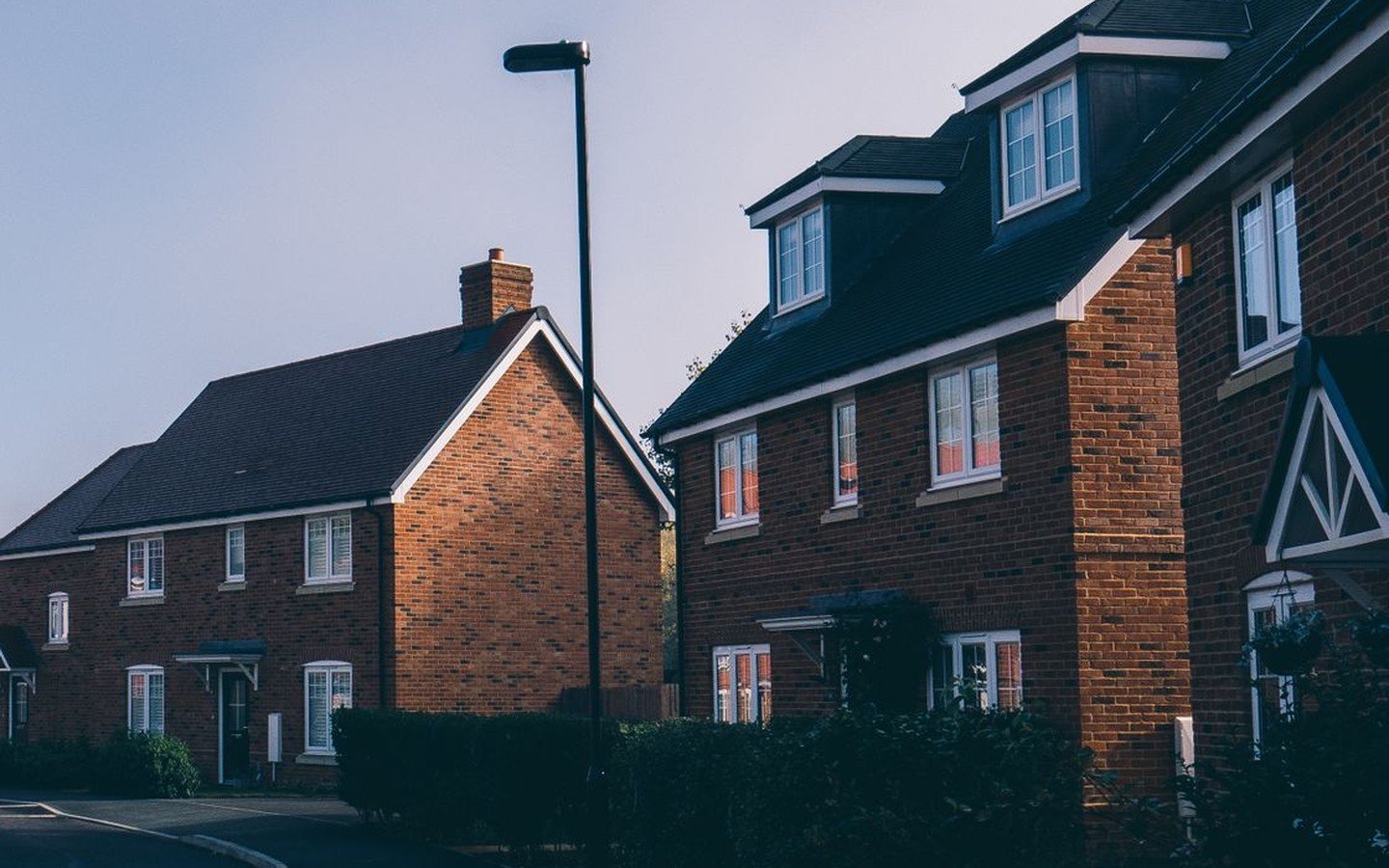 Modern red brick houses along a quiet residential street in Farnham at first light