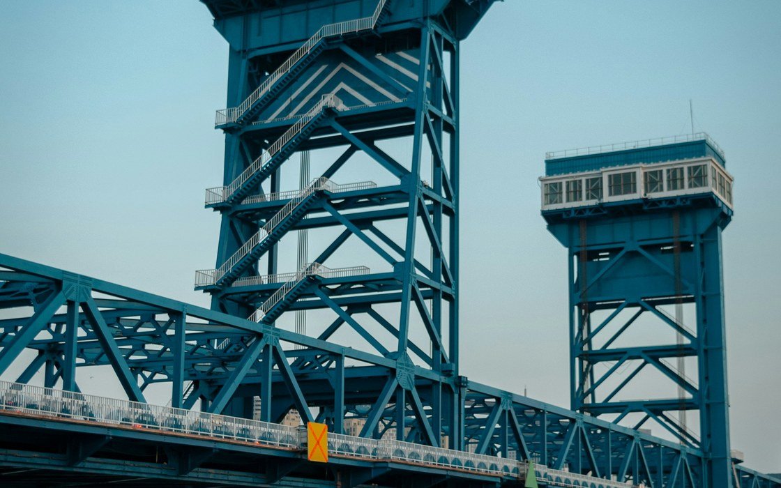 A blue steel lifting bridge with two lattice towers and an operator cabin above the deck