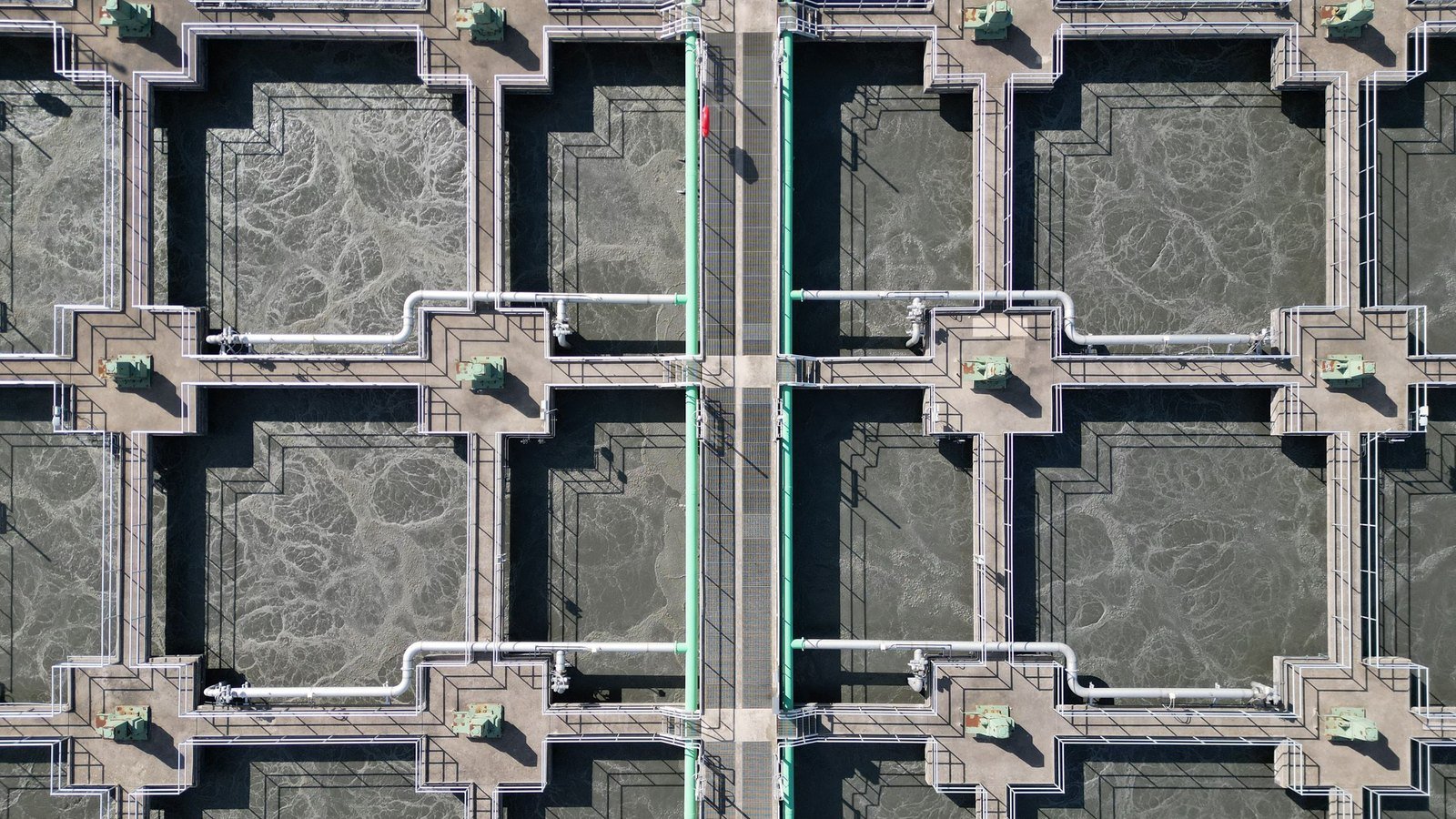 Rectangular sedimentation tanks and pipework at a water treatment works seen from above