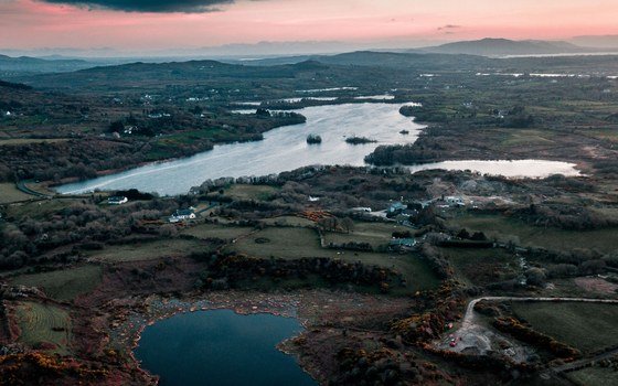 Lakes, fields and low hills in County Mayo seen from the air at sunset