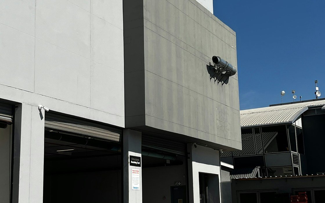 A modern single storey industrial building with a plain concrete panel elevation and roller shutter loading doors