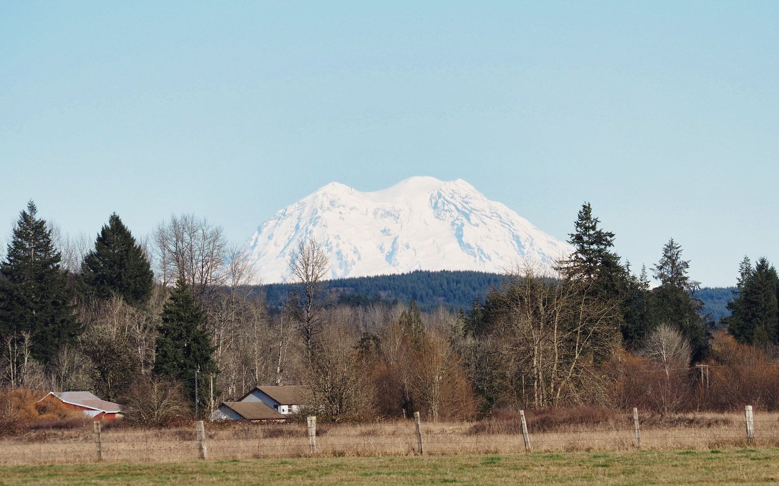 Snow-capped Mount Rainier rising above forest and farmland in rural Washington