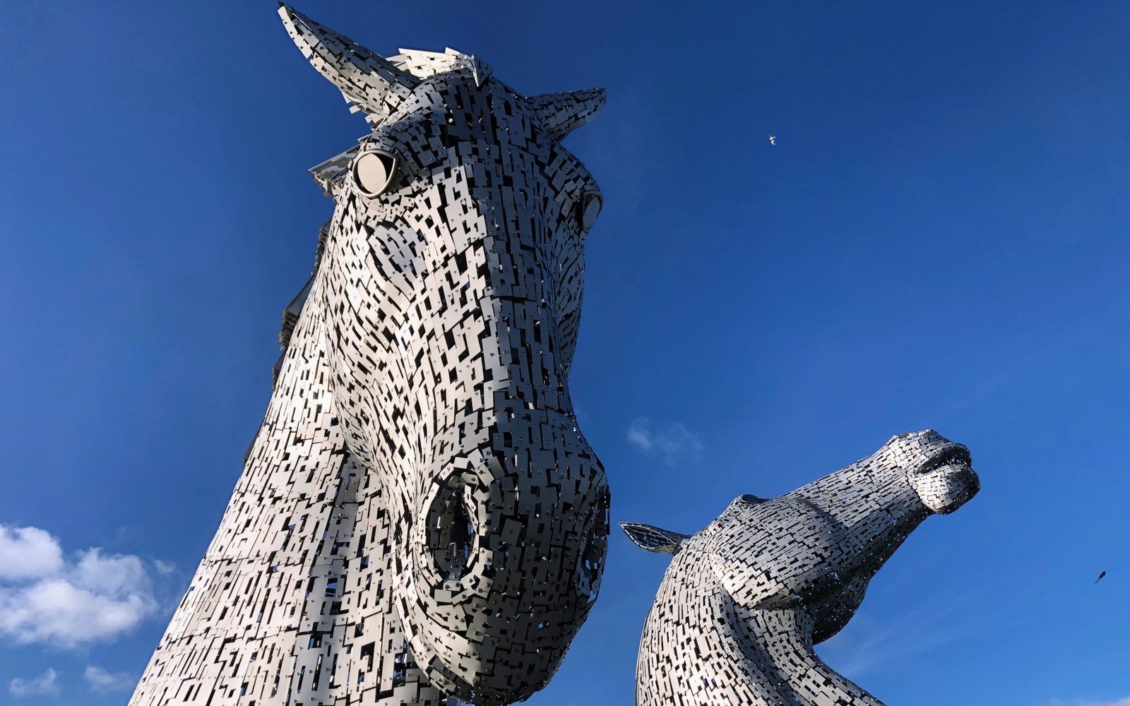 The Kelpies, two giant steel horse head sculptures at Falkirk, against a deep blue sky