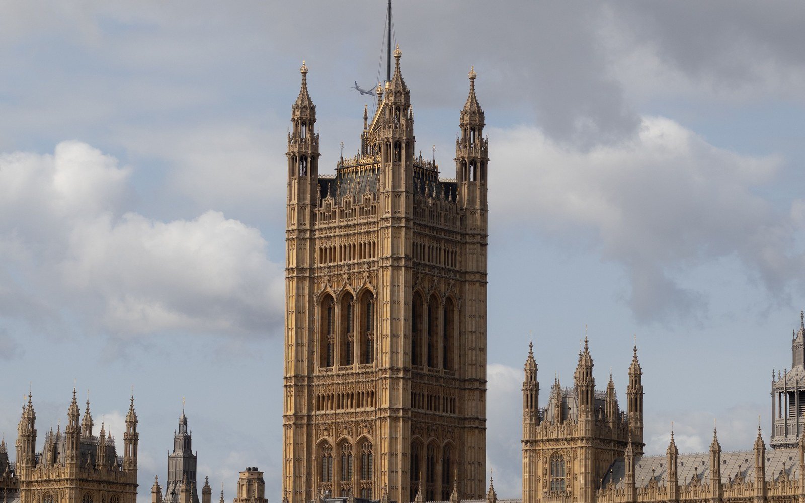 The Victoria Tower and the river front of the Palace of Westminster in London under a bank of cloud