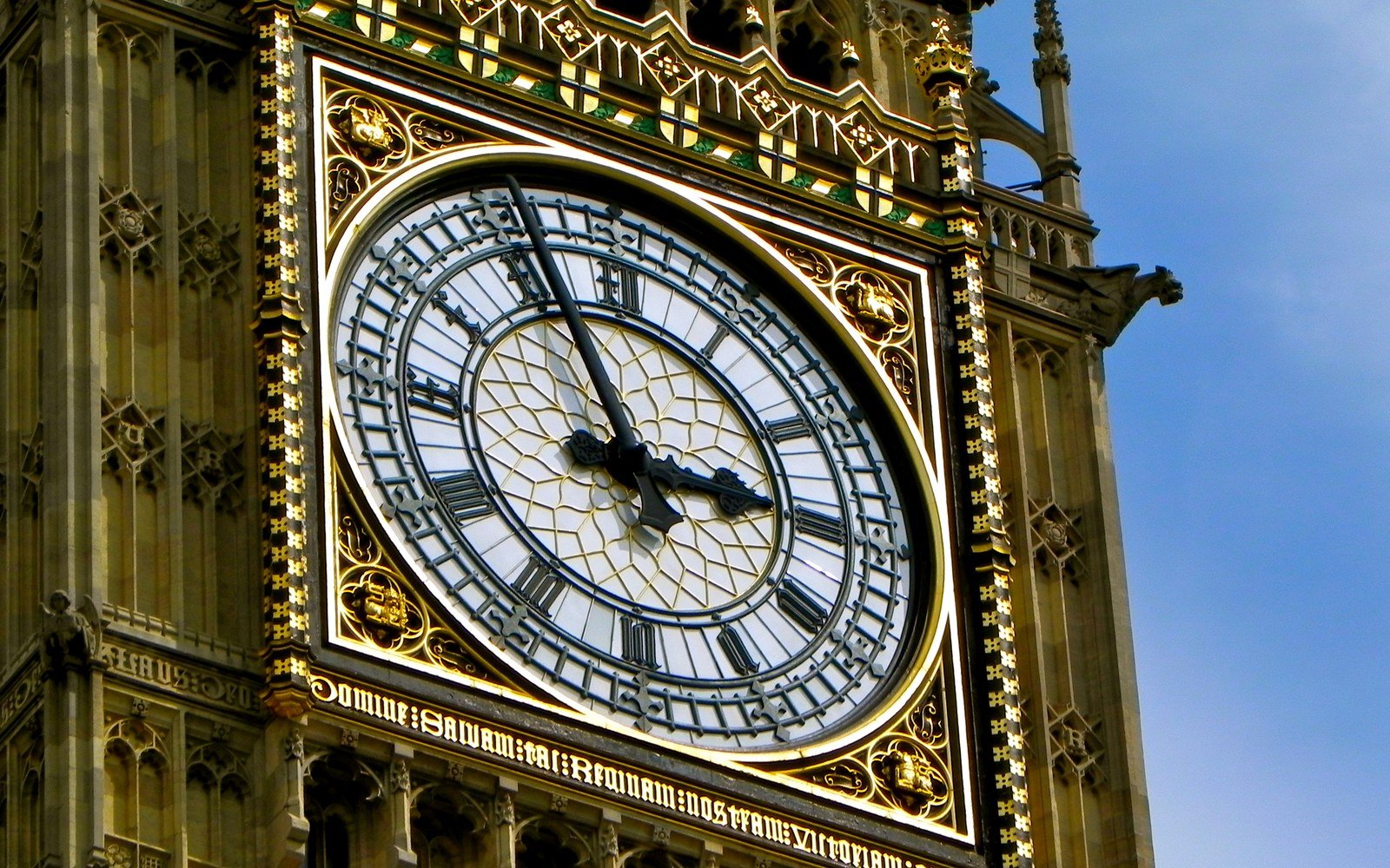 The illuminated clock face of the Elizabeth Tower at Westminster seen close up against a clear sky