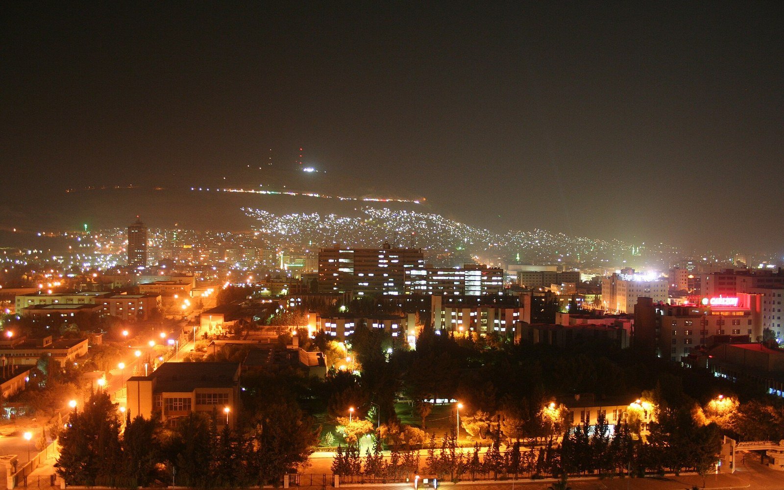 Damascus at night seen from the slope of Mount Qasioun, the lights of the city spreading up the hillside