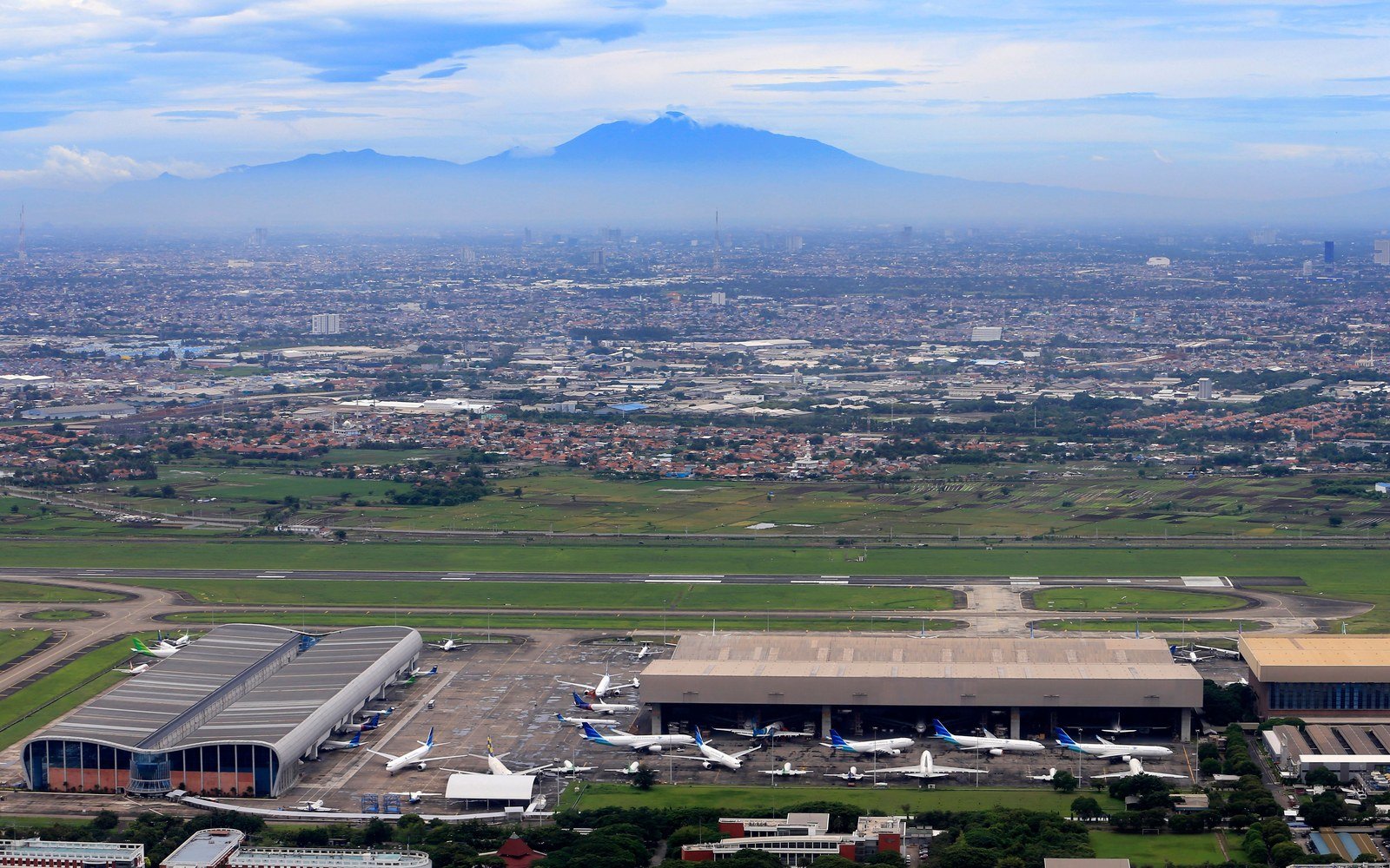 Aerial view of Soekarno-Hatta International Airport serving Jakarta with a volcano on the horizon