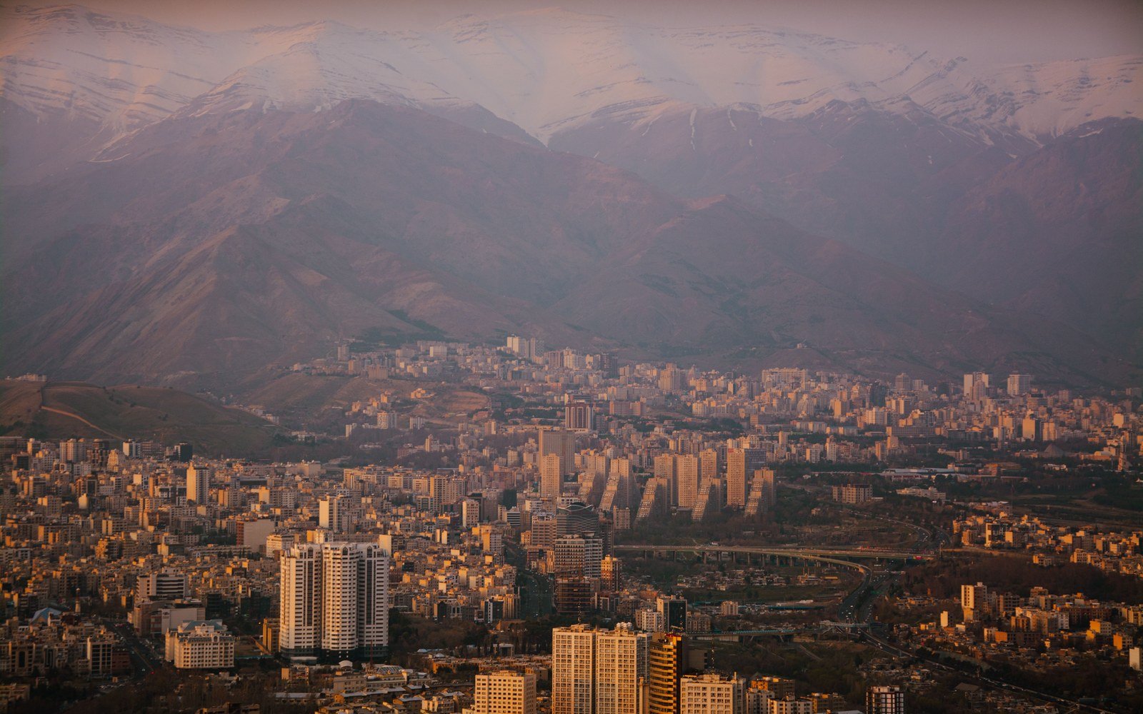 The Tehran cityscape at twilight with the Alborz mountains behind