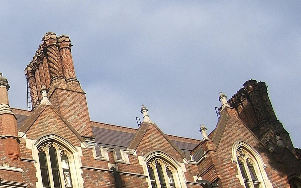 Red brick gables, stone tracery windows and tall patterned chimneys of a Victorian building at Lincoln's Inn under a grey sky