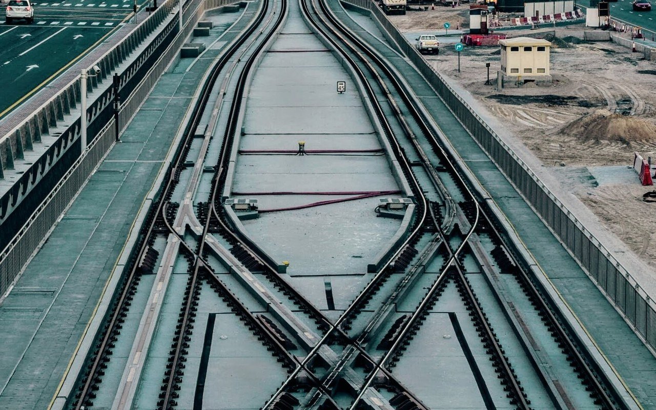 Tram tracks and a crossover running along a raised tramway in Dubai beside a busy road